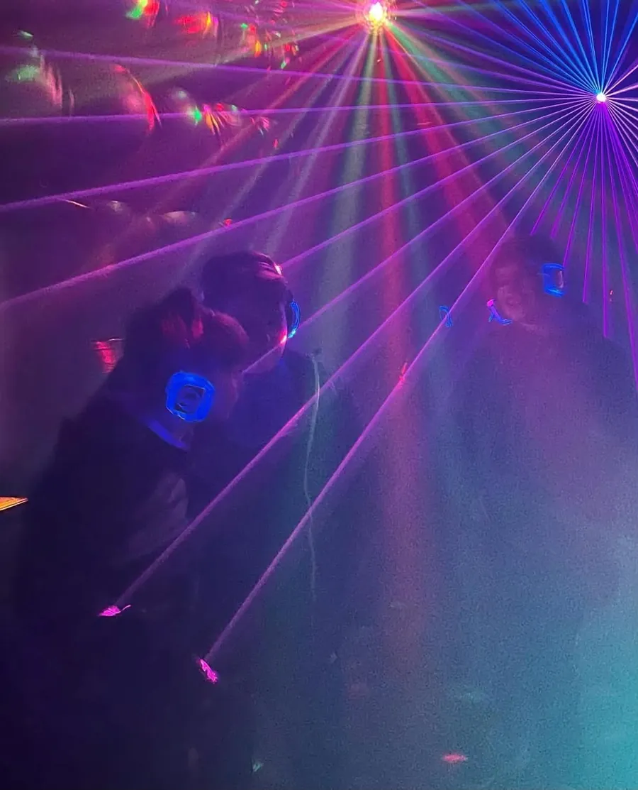 Gæster med lysende hovedtelefoner til silent disco under lasere